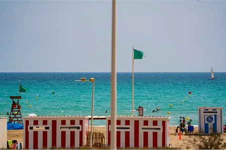 Casetas de socorrista y bandera verde en la playa de Canet d'en Berenguer